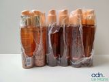 four bottles of lotion are wrapped in plastic bags on a table