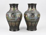 pair of black vases with multicolored designs on them on a white background