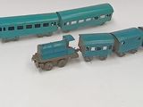 several toy trains are lined up on a white surface