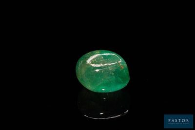 un gros plan d'une émeraude verte sur une surface noire