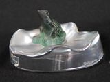 a glass figurine of a bird sitting on a leaf