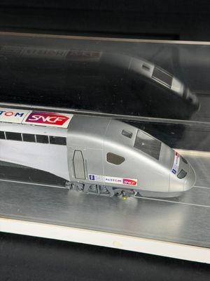 a model of a silver train on display in a glass case
