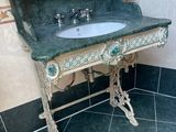 a green marble sink in a bathroom with a tiled floor