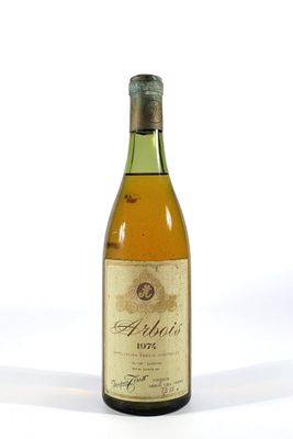 une vieille bouteille de vin posée sur une surface blanche