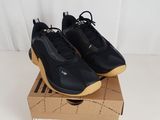 a pair of black sneakers sitting on top of a cardboard box