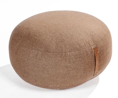 a close up of a round ottoman sitting on a white surface