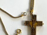 collier avec une croix suspendue à une chaîne, sur un fond blanc