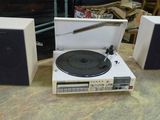 deux haut-parleurs et un tourne-disque posés sur une table