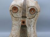 une image représentant un masque en bois sur fond gris