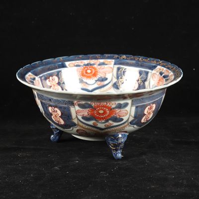 an old blue and white bowl sitting on top of a black table