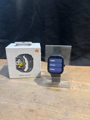 une Apple Watch posée à côté d'une boîte sur une table en bois
