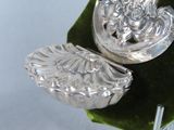 a silver object on a green leaf on a table