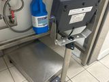 une machine posée par terre à côté d'un conteneur bleu