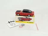 une petite voiture rouge dans une boîte avec un bâtonnet