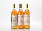 three bottles of wine sitting next to each other on a white surface