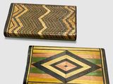 pair of wooden boxes with geometric designs on them sitting on a table