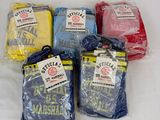 Plusieurs t-shirts de différentes couleurs sont emballés dans des sacs en plastique, posés sur une surface blanche.