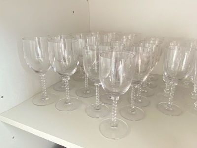 de nombreux verres à vin vides posés sur une étagère dans une pièce