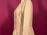 a brown jacket on a mannequin stand against a red wall