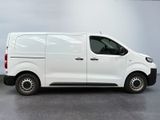 the white van is parked in a large room with a gray floor