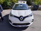 un homme debout à côté d'une voiture blanche sur un parking
