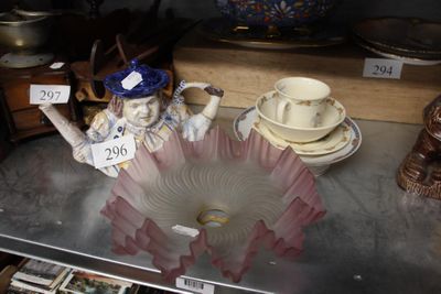 une statue représentant une femme tenant une tasse et une soucoupe posées sur une table