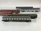 several toy trains are lined up in a row on a white surface