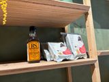 a wooden shelf with a bottle of tea and some tea bags on it