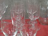 several empty wine glasses and a decanter on a red cloth