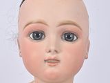 a close up of a doll wearing a white dress