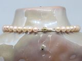 a close up of a vase with a pearl necklace on it