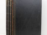 a black book sitting on top of a white table next to a white wall