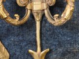 a gold candle holder and two candles on a blue background