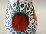 a white vase with a black and red design on it