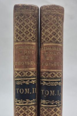 deux vieux livres posés l'un sur l'autre sur une table