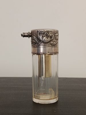 a small glass jar with a silver lid on a table