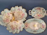 three pieces of china on display on a blue table