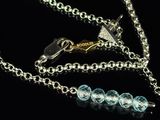 a silver chain with a blue bead on it