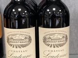 deux bouteilles de vin rouge posées sur un comptoir, à côté d'une bouteille de vin