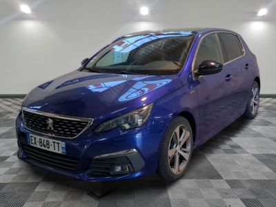 la voiture bleue est garée sur un sol en damier dans le garage