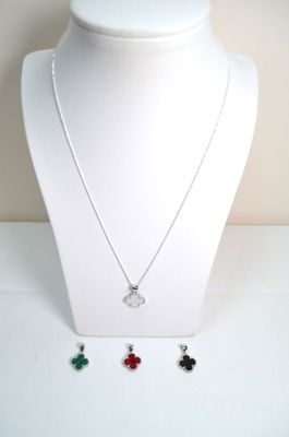 silver necklace with four clover charms on a white mannequin