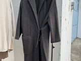 two coats hanging on a clothes rack outside of a building