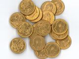 une pile de pièces d'or posée sur une surface blanche