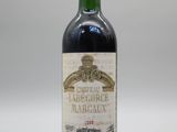 une bouteille de vin rouge posée sur une table blanche