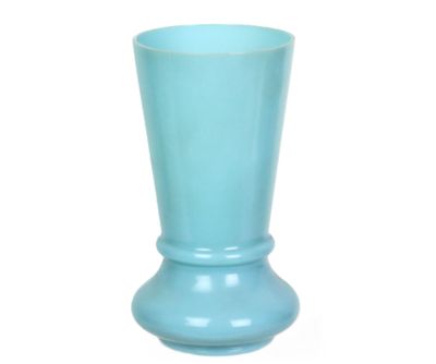 un vase bleu posé sur une surface blanche