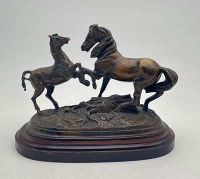 bronze statue of two horses on a wooden base on a white background