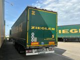 un camion qui roule sur la route à côté d'un immeuble
