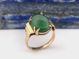 Gros plan sur une bague ornée d'une pierre verte
