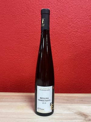 a bottle of wine sitting on top of a wooden table