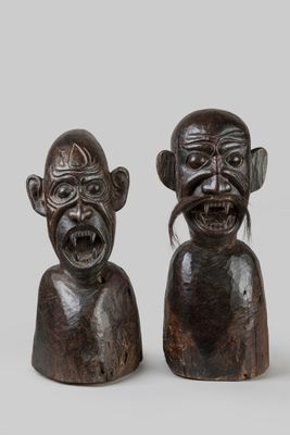 pair of carved wooden figurines of two men with different facial expressions